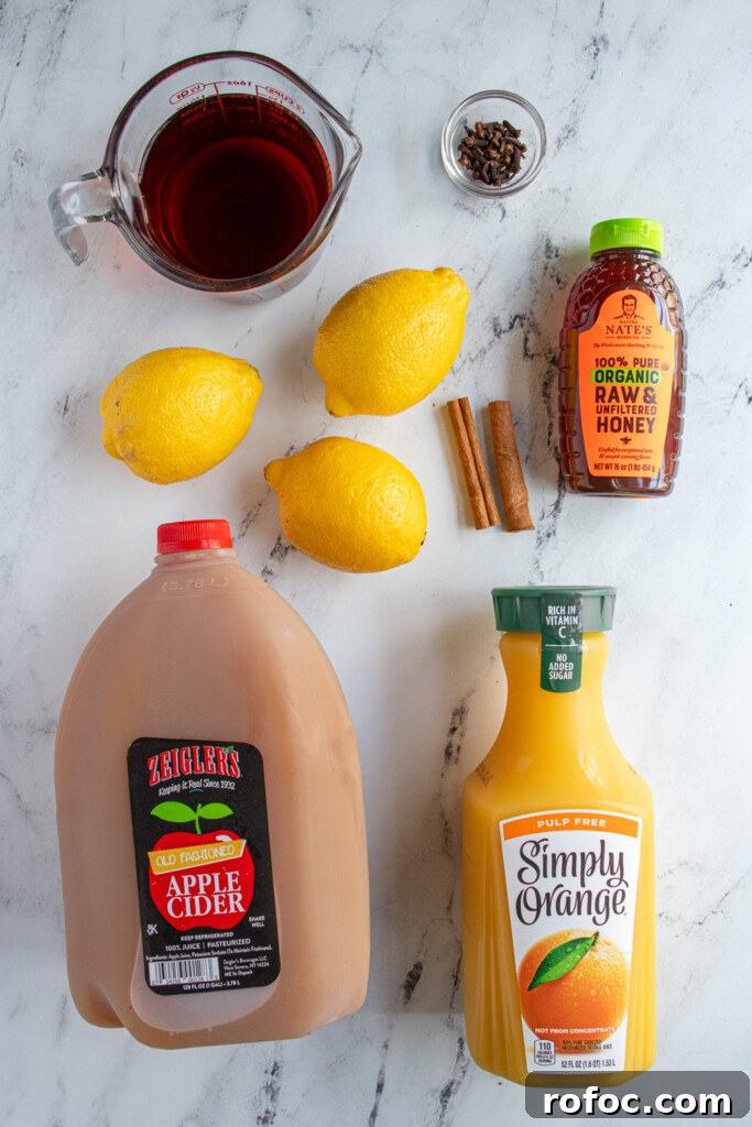 Slow-Cooker Christmas Wassail Recipe for Festive Parties 5 Ingredients needed to make crockpot Christmas wassail all laid out on a table top.