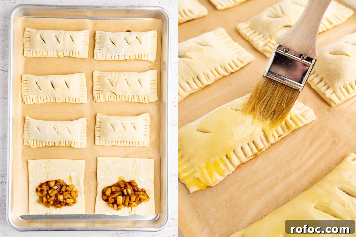 Homemade Apple Hand Pies: Flaky Mini Pastry Recipe 5 partially assembled apple hand pies on a baking sheet before going into the oven. Six pies are finished with two still open before folding over the puff pastry.
