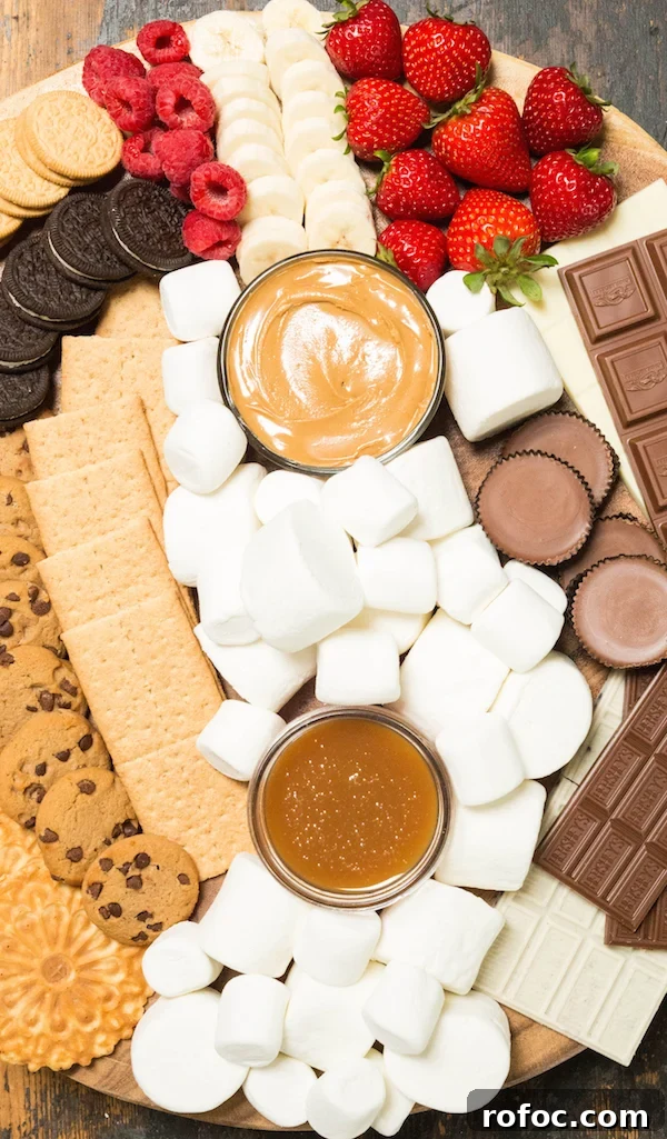 S'mores Party Board Ideas for Gatherings and Dessert Nights 5 S'mores board marshmallows and toppings like fresh fruit, caramel, and peanut butter.