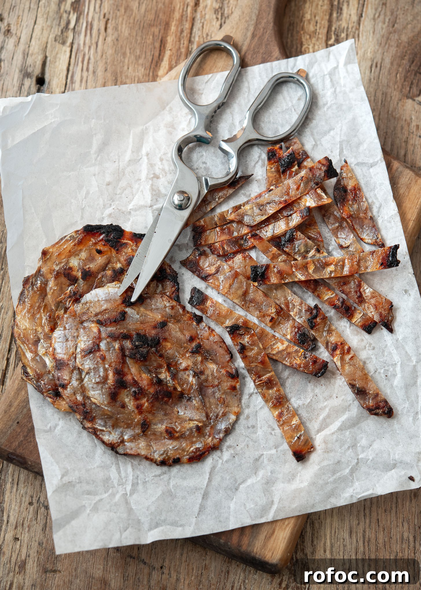 Korean-Style Jwipo Fish Jerky: Spicy Dried Fish Snack Guide 5 Roasted dried filefish (jwipo) is cut into bite size strips with a pair of scissor.