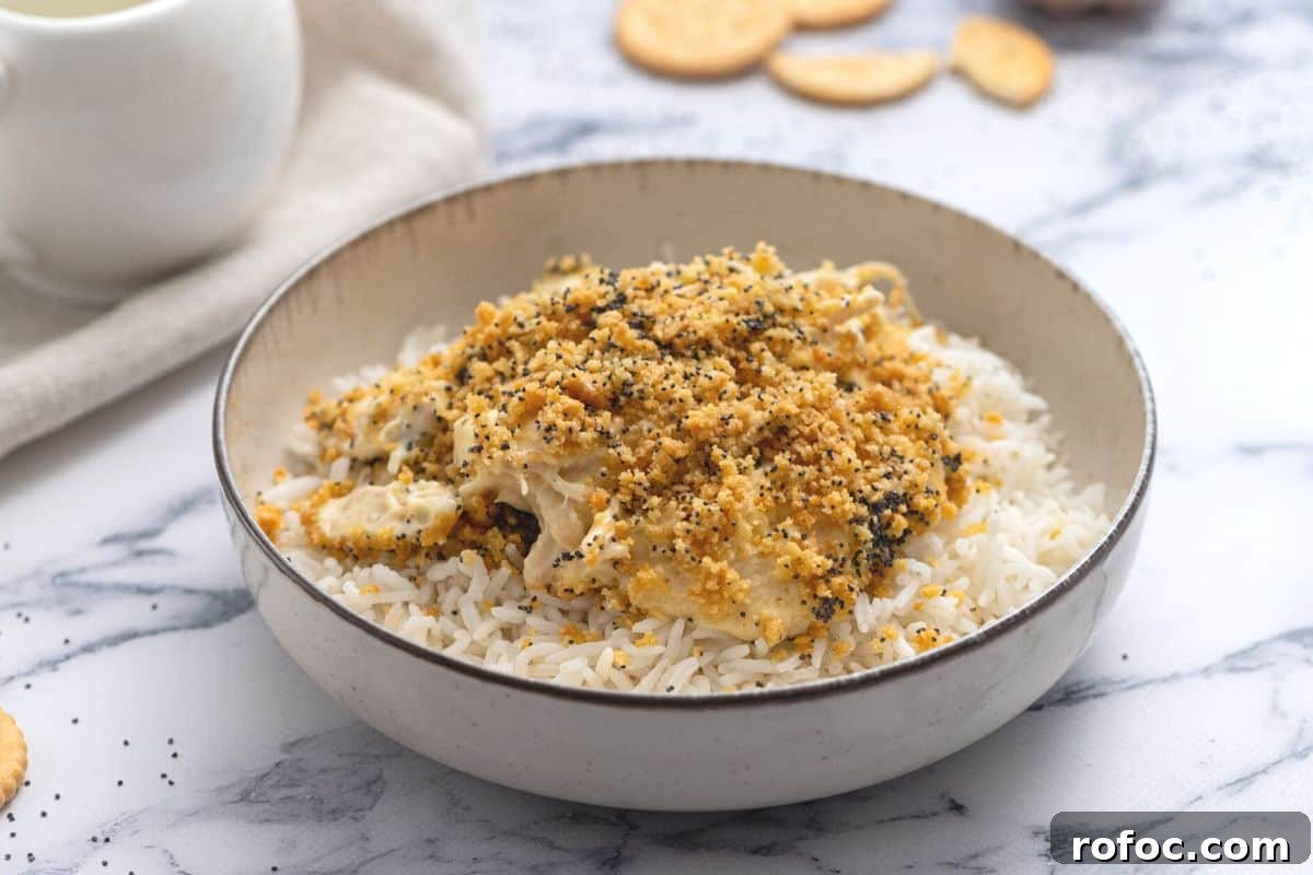 Healthy Poppy Seed Chicken Poppy Seed Chicken served over rice with butter crackers in the background.