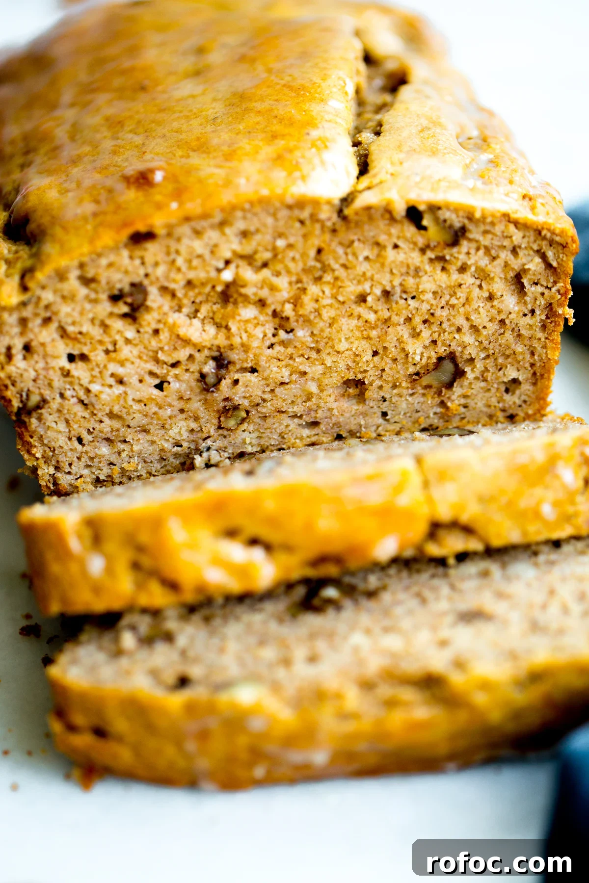 close up photo of a loaf of healthy no added sugar banana bread with two slices cut