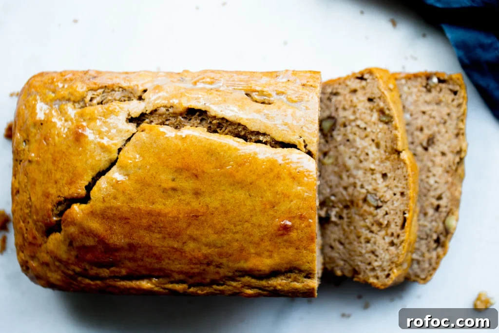 overhead shot of sliced banana bread loaf on marble background with blue napkin