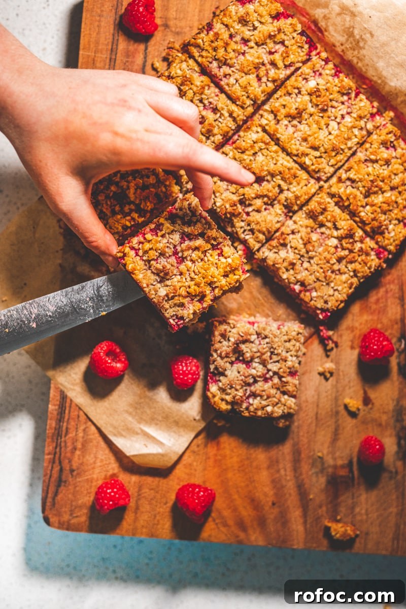 Coconut and Raspberry Flapjacks — Chewy Oat Bars Recipe 4 Coconut & Raspberry Flapjacks on a board - Georgie Eats
