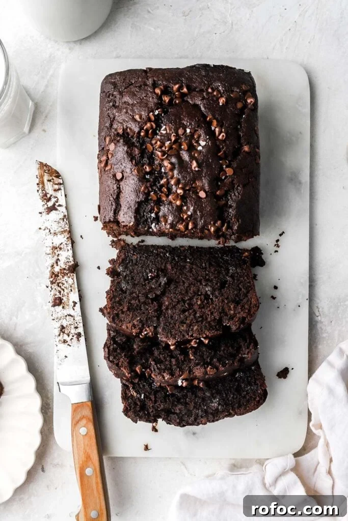 Decadent Chocolate Banana Bread Recipe with Melted Chips 2 sliced chocolate banana bread with mini chocolate chips on top
