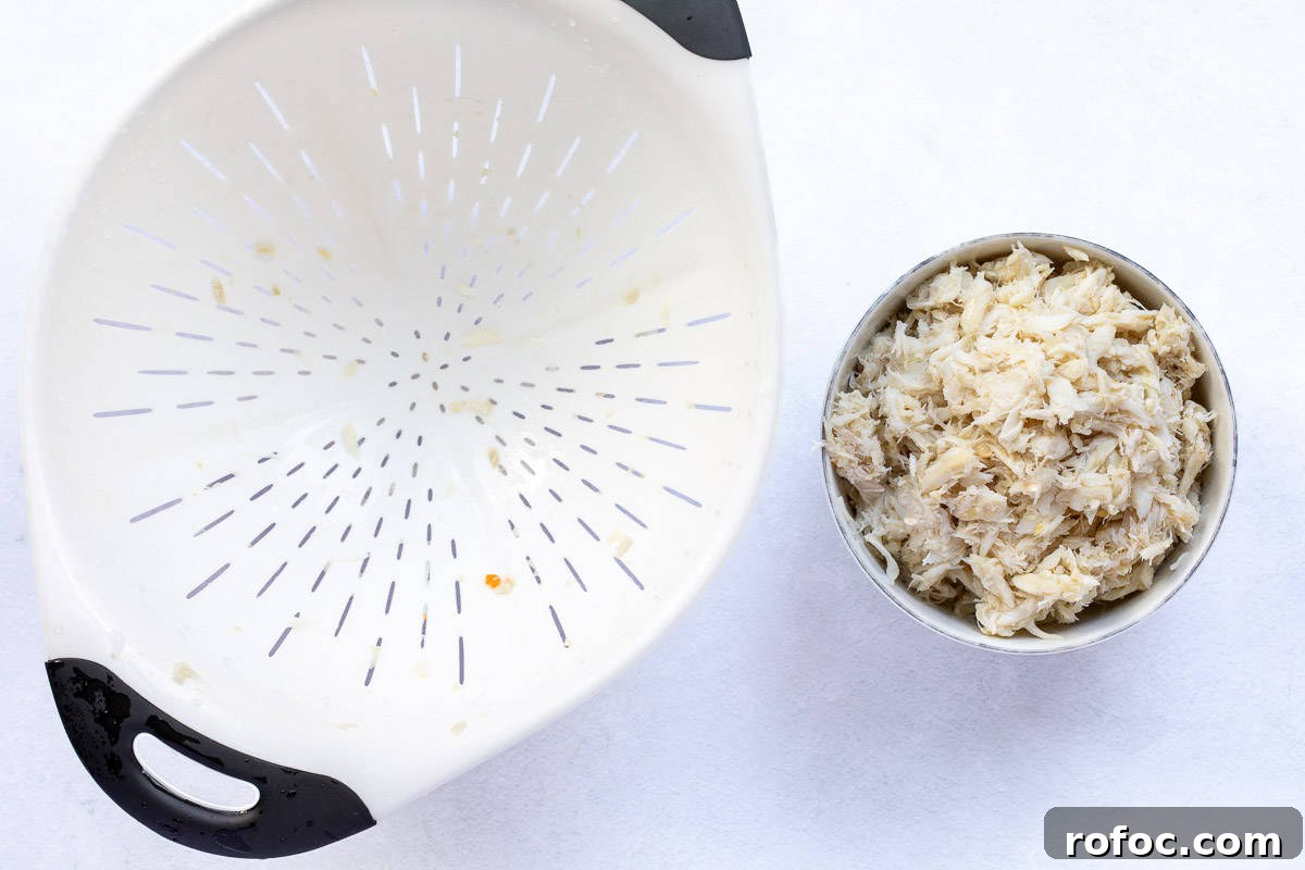 Creamy Baked Crab Dip with Garlic and Parmesan 4 lump crabmeat in small bowl next to strainer.