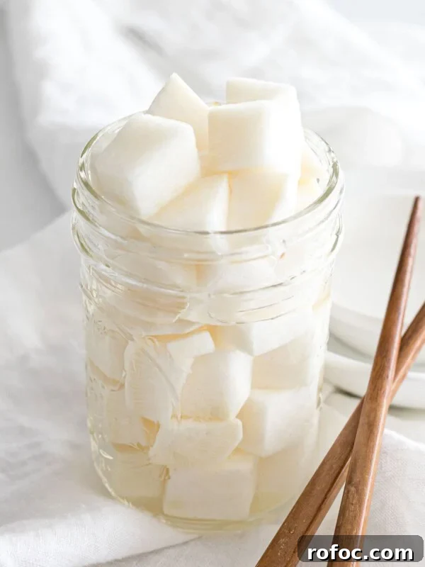 Authentic Doenjang Jjigae Recipe: Korean Soybean Paste Stew Guide 14 Korean pickled radish in a glass jar next to chopsticks