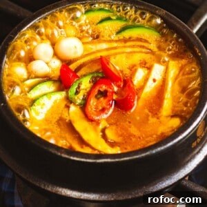 Authentic Doenjang Jjigae Recipe: Korean Soybean Paste Stew Guide 15 Doenjang jjigae with mushrooms, tofu, and peppers boiling in a pot.