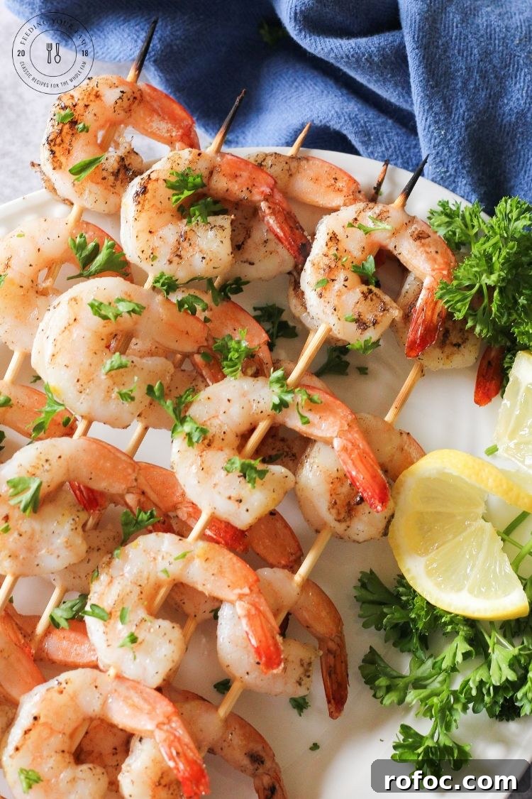 Easy grilled shrimp skewers with lemon and parsley grilled shrimp skewers on a white plate with lemon and parsley