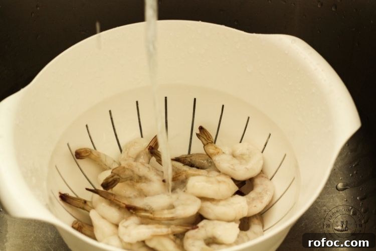 Perfect Grilled Shrimp: Quick Charred Shrimp Recipe for Summer 2 frozen shrimp in a colander with running water