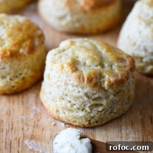 Close up of a golden top biscuit on a cutting board.