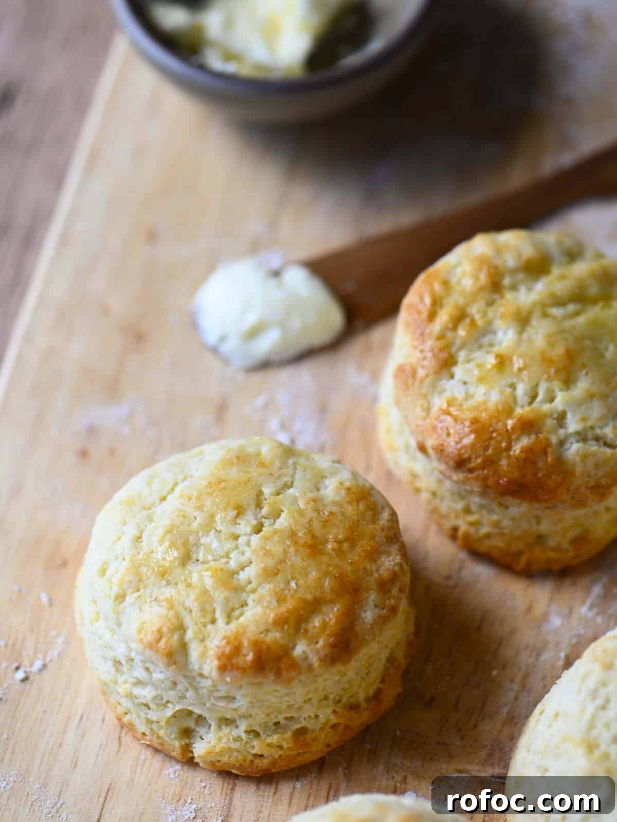 Angled view of biscuits on a cutting board with butter.