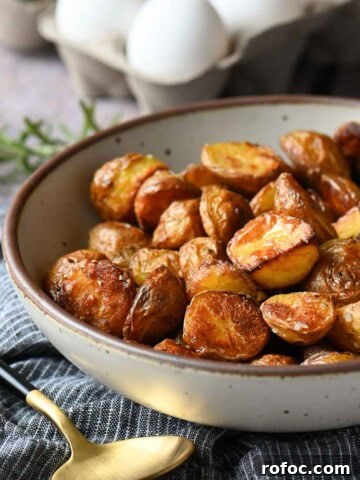 Bowl of roasted potatoes on a blue striped napkin.