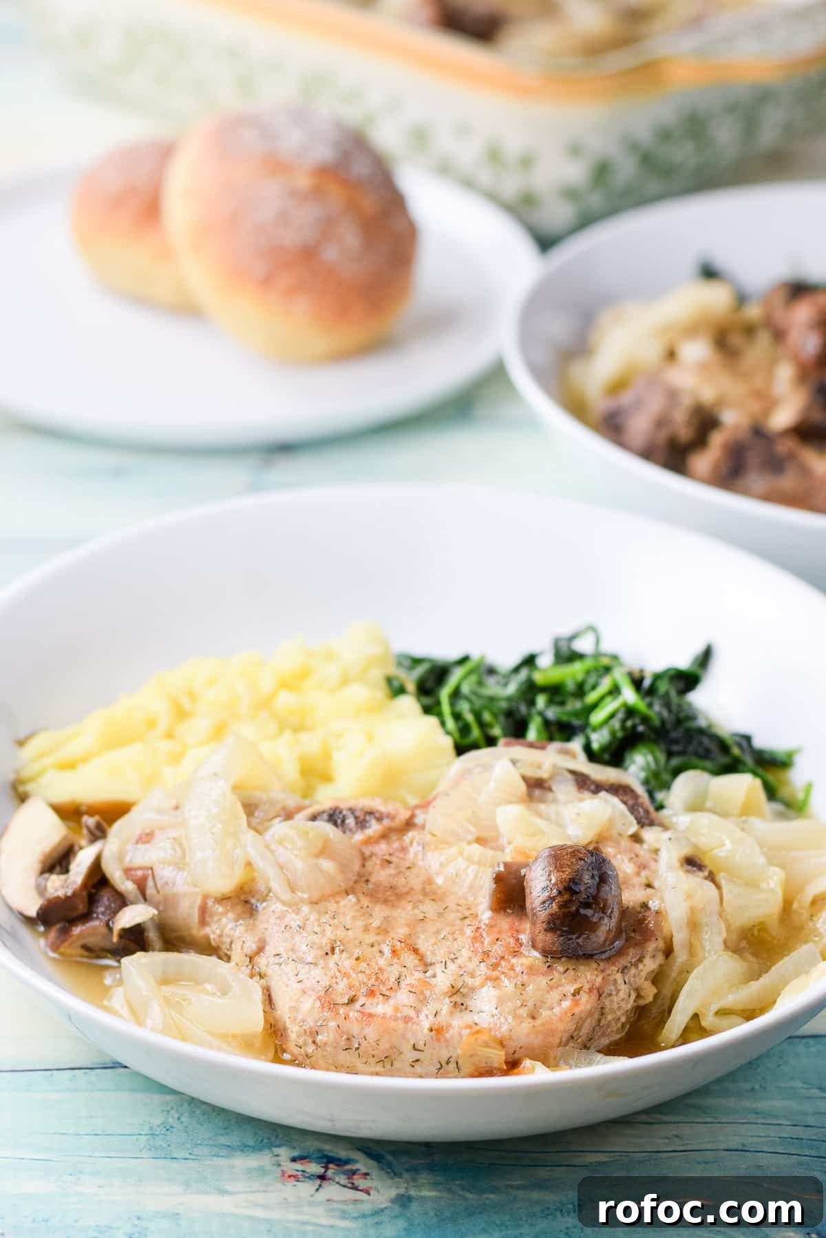 Juicy Pan-Seared Pork Chops with Garlic Butter Sauce 8 A pork chop with mushrooms, onions, potato and spinach