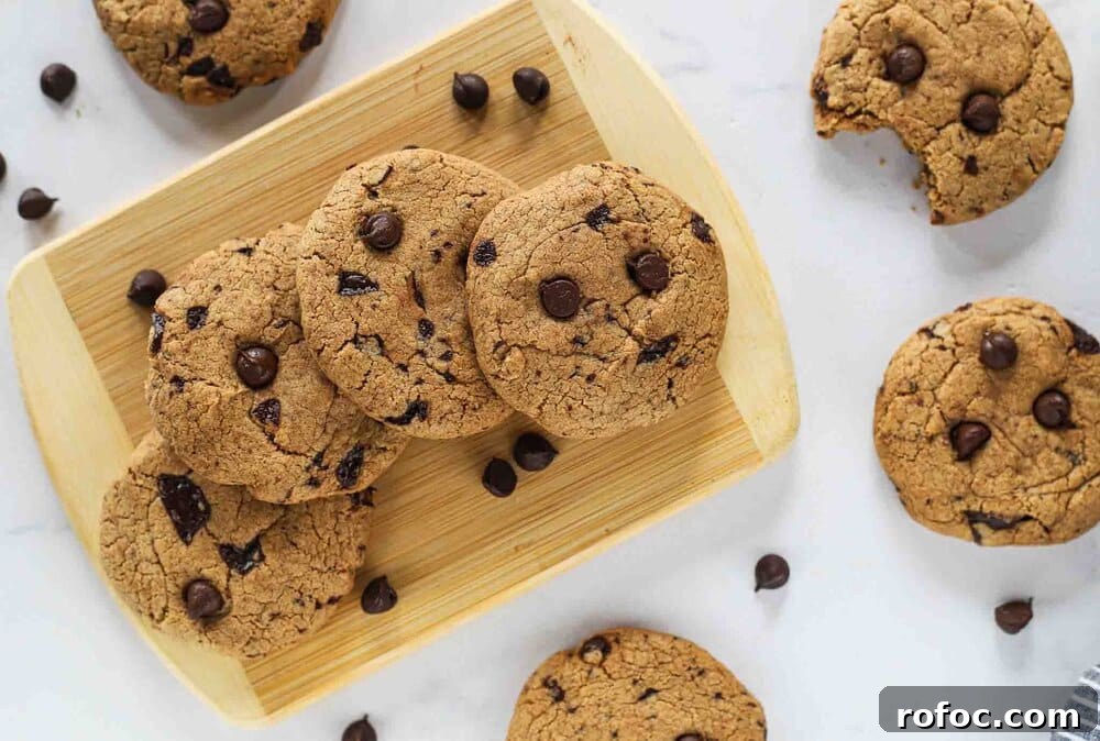 Ultimate Chewy Chocolate Chip Cookies Made with Melted Butter 3 Cookies on a board with cookies surrounding it.