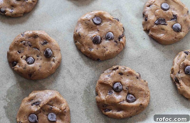 Ultimate Chewy Chocolate Chip Cookies Made with Melted Butter 6 Unbaked cookies on a baking sheet.