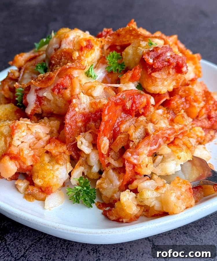 Tater Tot Pizza Casserole Recipe for Family Weeknight Meals 9 Tasty pizza casserole made with frozen tater tots on a plate ready to eat. A comfort food dinner for a family with picky eaters that can be customized with lots of different pizza toppings.