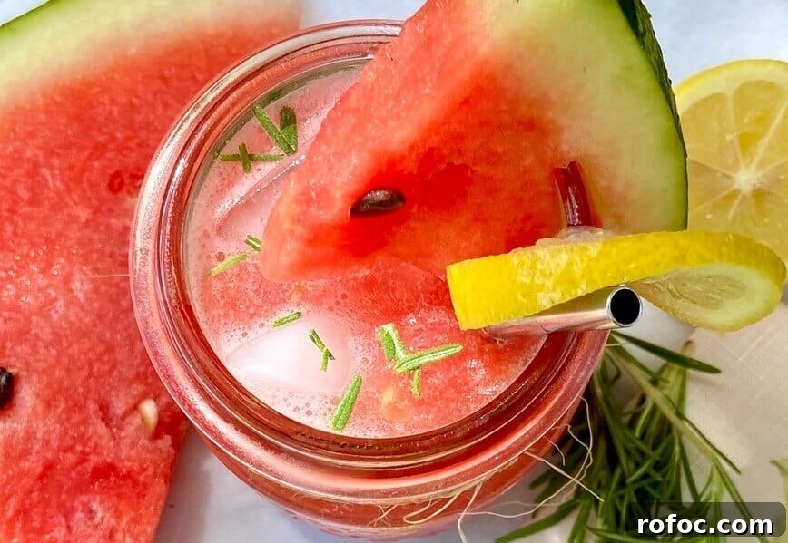 Watermelon Lemonade Infused with Fresh Rosemary 4 Lemonade garnished with rosemary, a slice of watermelon, and a slice of lemon.