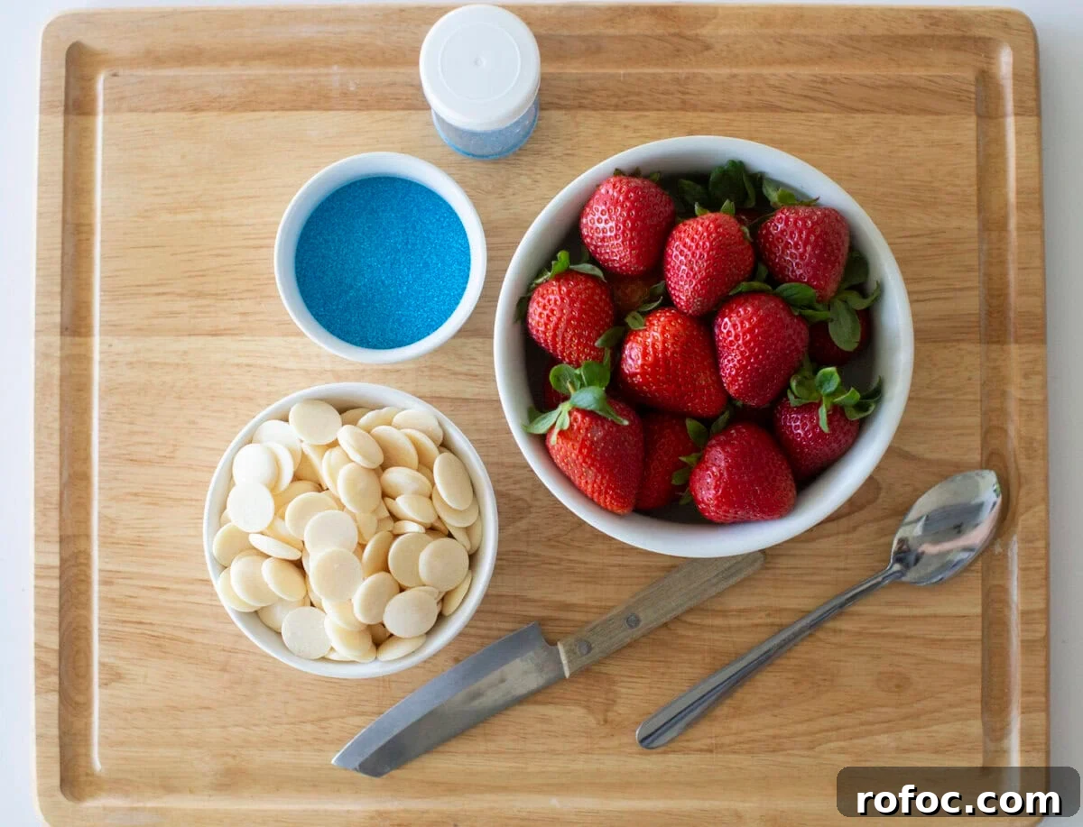 Patriotic Dipped Strawberries for 4th of July Celebrations 3 A wooden cutting board with a bowl of fresh strawberries, a bowl of white chocolate melts, a bowl of blue sprinkles, a container of blue sprinkles, a metal spoon, and a knife.