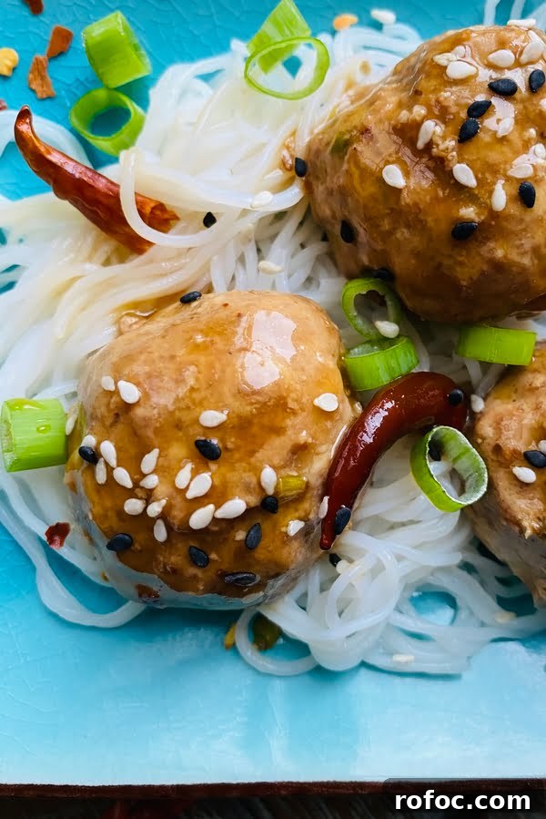 General Tso's meatballs over rice noodles and with peppers.