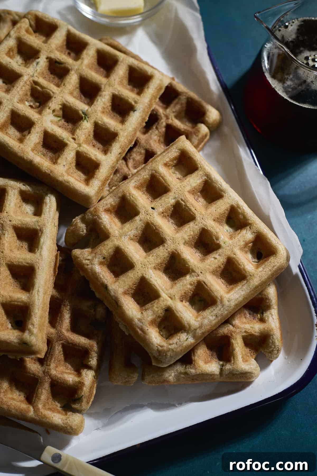 Sourdough Zucchini Waffles with Crispy Golden Crust 2 A stack of Sourdough Zucchini Waffles on a white tray.