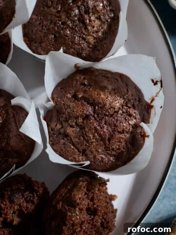Chocolate Sourdough Zucchini Muffins on a white platter.