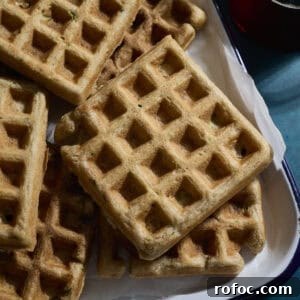 Sourdough Zucchini Waffles with Crispy Golden Crust 15 A stack of Sourdough Zucchini Waffles on a white tray.