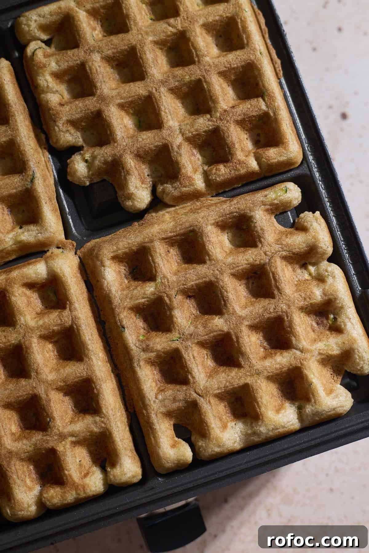 Sourdough Zucchini Waffles with Crispy Golden Crust 8 Waffles in the waffle iron after baking.