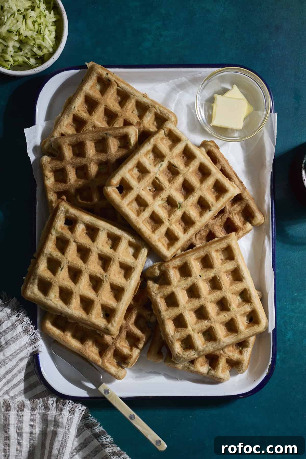 Sourdough Zucchini Waffles with Crispy Golden Crust 9 A stack of Sourdough Zucchini Waffles on a white tray.