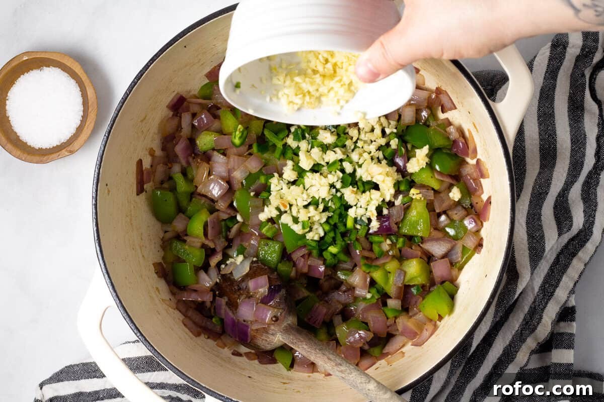 Large white pot filled with onions green peppers garlic and jalapeno
