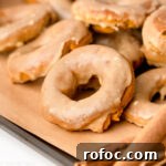 Pumpkin Spice Donuts with Maple Glaze: Fall Recipe Delight 11 Frosted pumpkin spice donuts on a baking sheet.