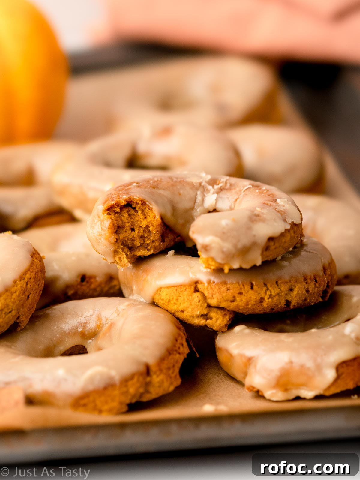 Pumpkin Spice Donuts with Maple Glaze: Fall Recipe Delight 4 Close-up of a maple glazed pumpkin spice donut with a bite taken out of it.