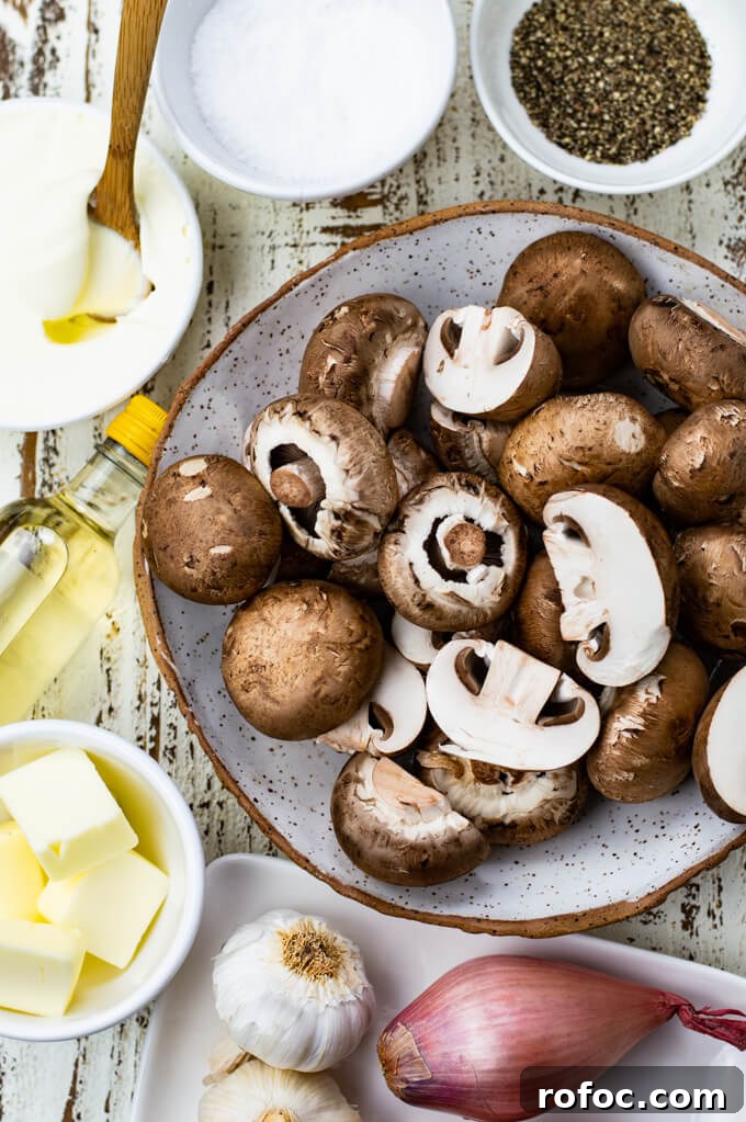 Creamy Mascarpone Garlic Mushrooms with Herbs and Toasted Bread 3 A bowl of raw mushrooms with butter shallots, sliced garlic and salt and pepper sit around the bowl.
