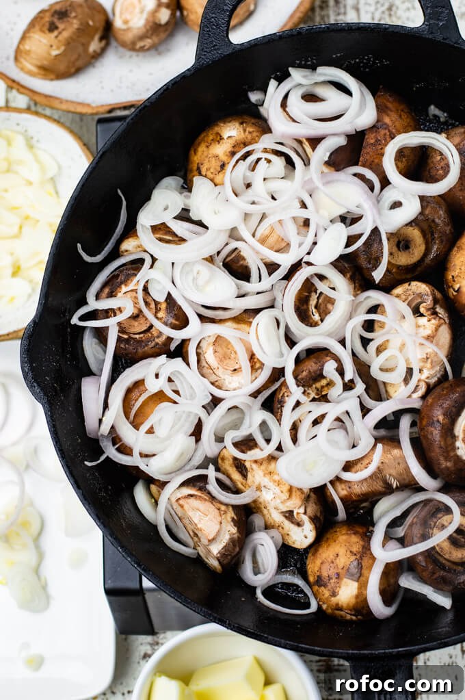 Creamy Mascarpone Garlic Mushrooms with Herbs and Toasted Bread 4 Mushrooms and sliced shallots are sautéing in a cast iron skillet. Bowls of mushroom, garlic, butter and shallots sit around the pan.