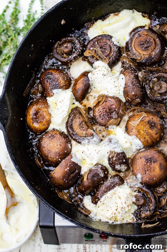 Creamy Mascarpone Garlic Mushrooms with Herbs and Toasted Bread 7 Sautéed mushrooms sit in a cast iron skillet with dollops of mascarpone cheese.