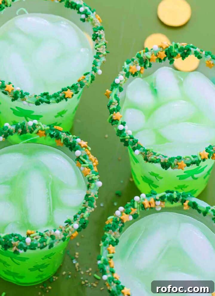 Four glasses of green cocktails for St. Patrick's day on a green tray with gold coins.