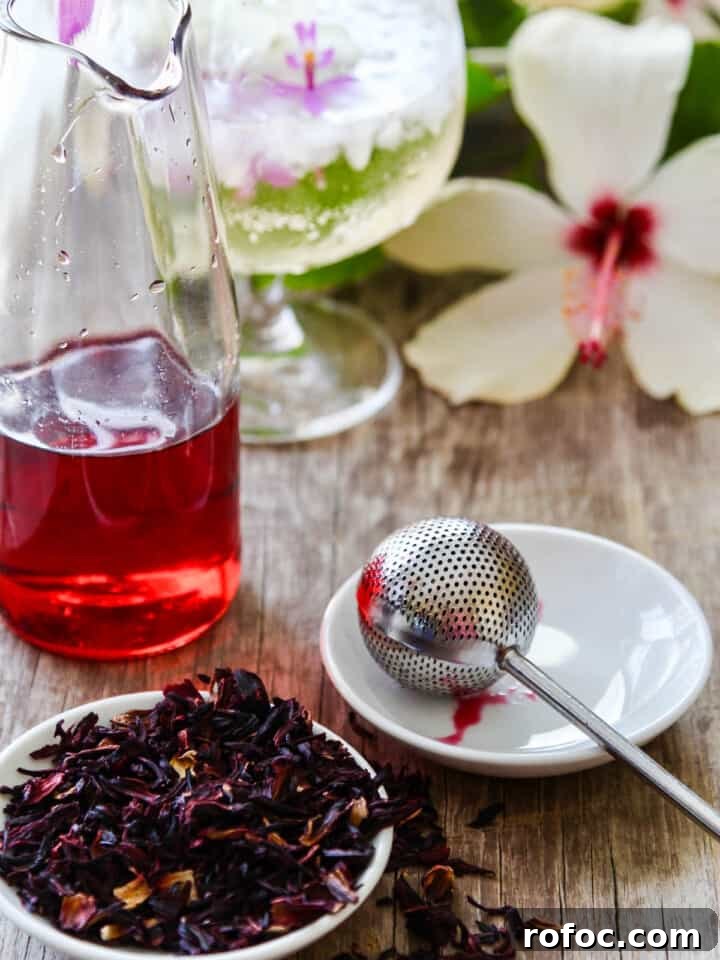 9 Refreshing Hibiscus Cocktail Recipes for Any Occasion 3 Making hibiscus tea using real tea, a strainer, and hot water.