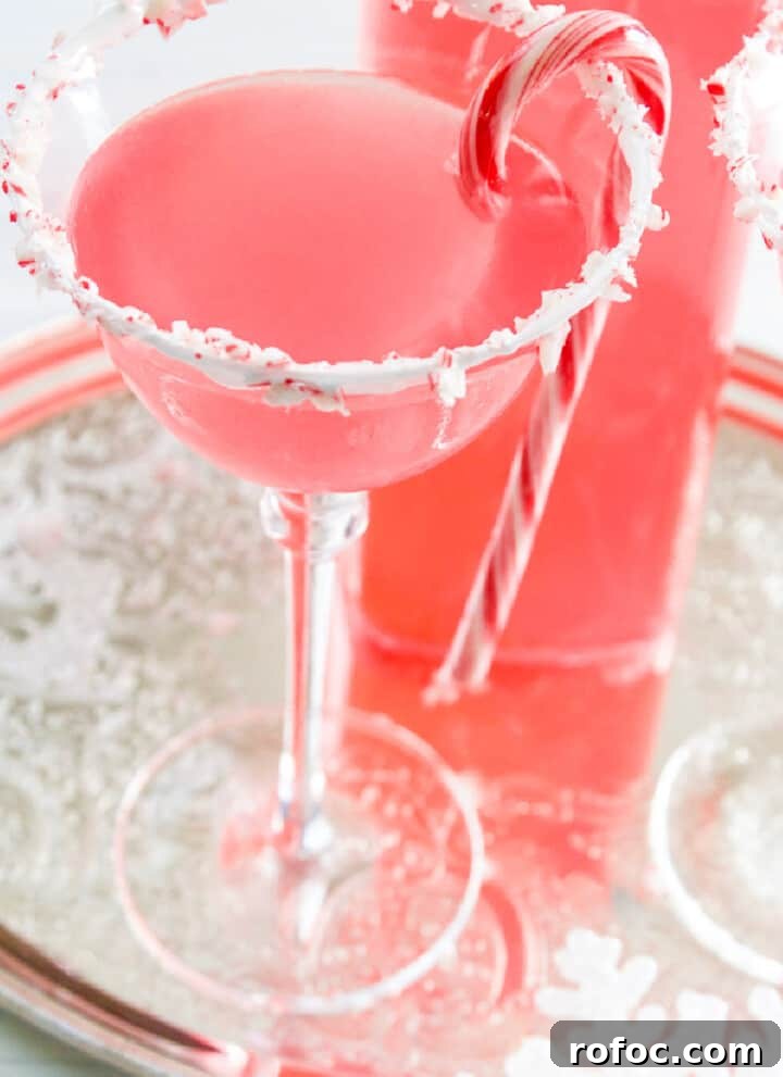 A silver tray with Candy Cane Martinis with crushed peppermint rim and candy cane garnish.