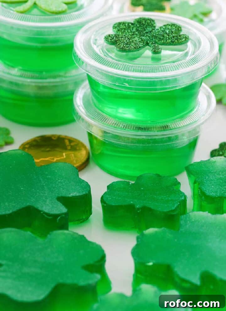 A white rectangle platter with green jello shots and jigglers shaped like shamrocks.