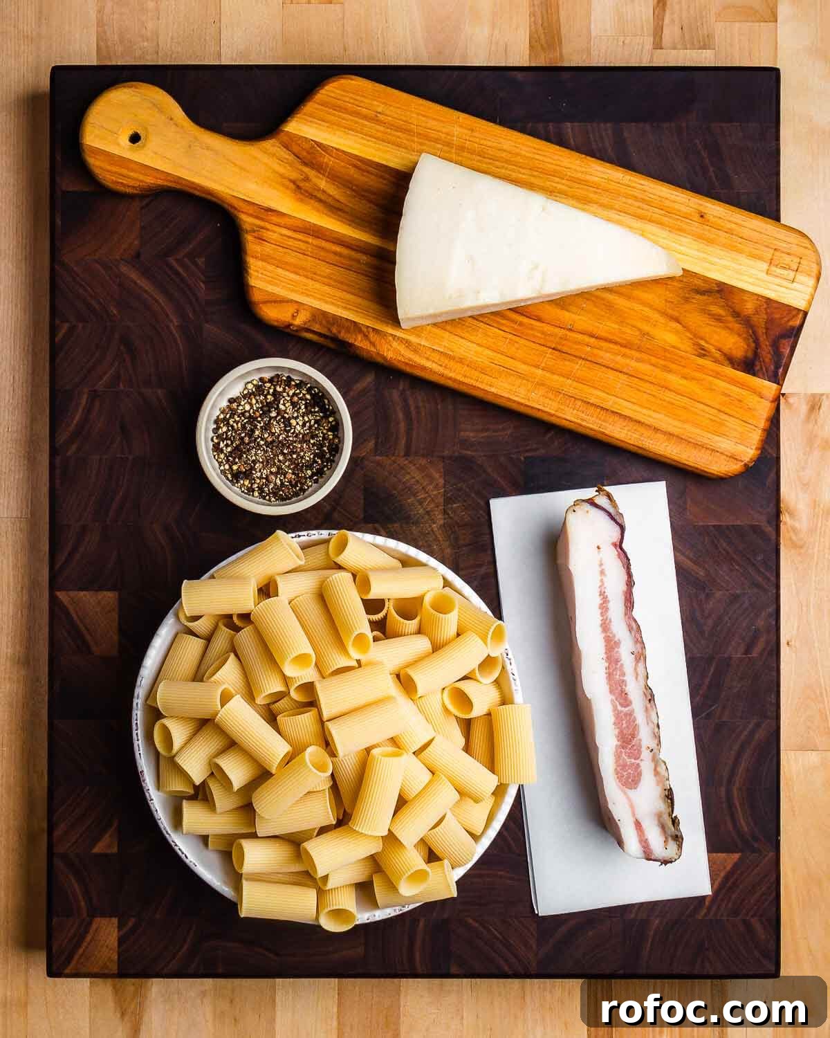 Rigatoni alla Gricia Recipe: Classic Roman Pork-Bacon Pasta 3 Ingredients shown: Pecorino Romano, pepper, rigatoni, and guanciale.