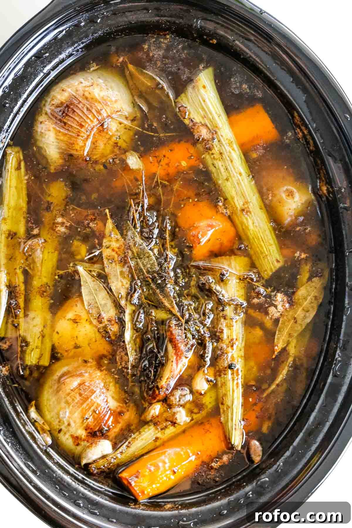 Rich Homemade Beef Bone Broth Recipe for Deep Flavor and Nutrition 11 cooked veggies in slow cooker.