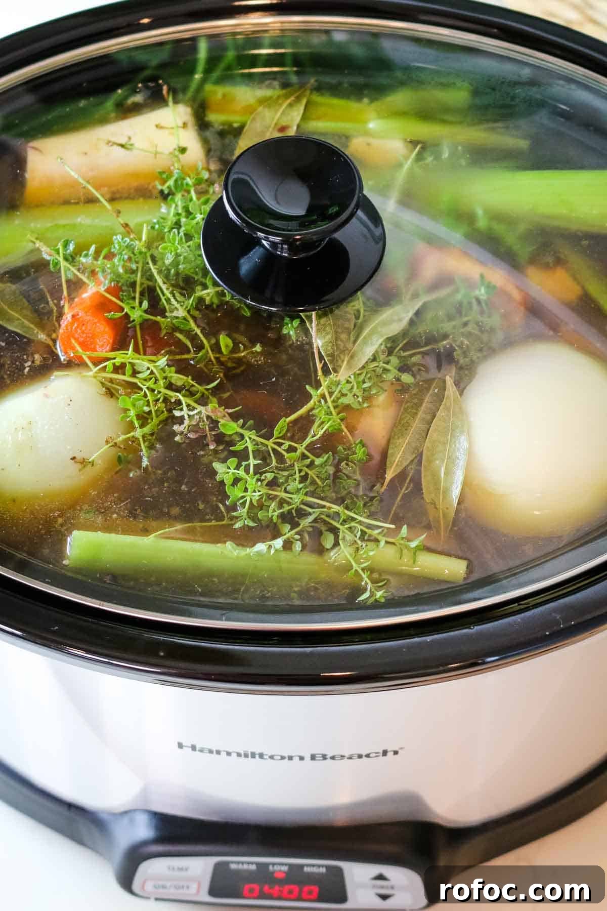 Rich Homemade Beef Bone Broth Recipe for Deep Flavor and Nutrition 10 closed slow cooker with vegetables.