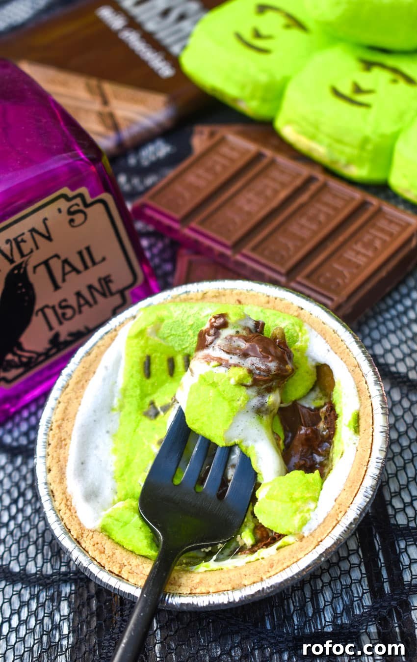 a black fork digging into a halloween peeps mini s'mores pie