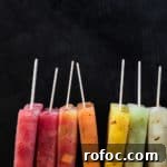 Spiced Watermelon Popsicles: Vibrant, Refreshing Summer Treat 8 Colorful melon popsicles on top of red, orange, yellow and green melon ice.