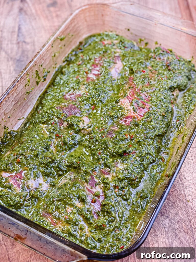 skirt steak in a dish covered with chimichurri