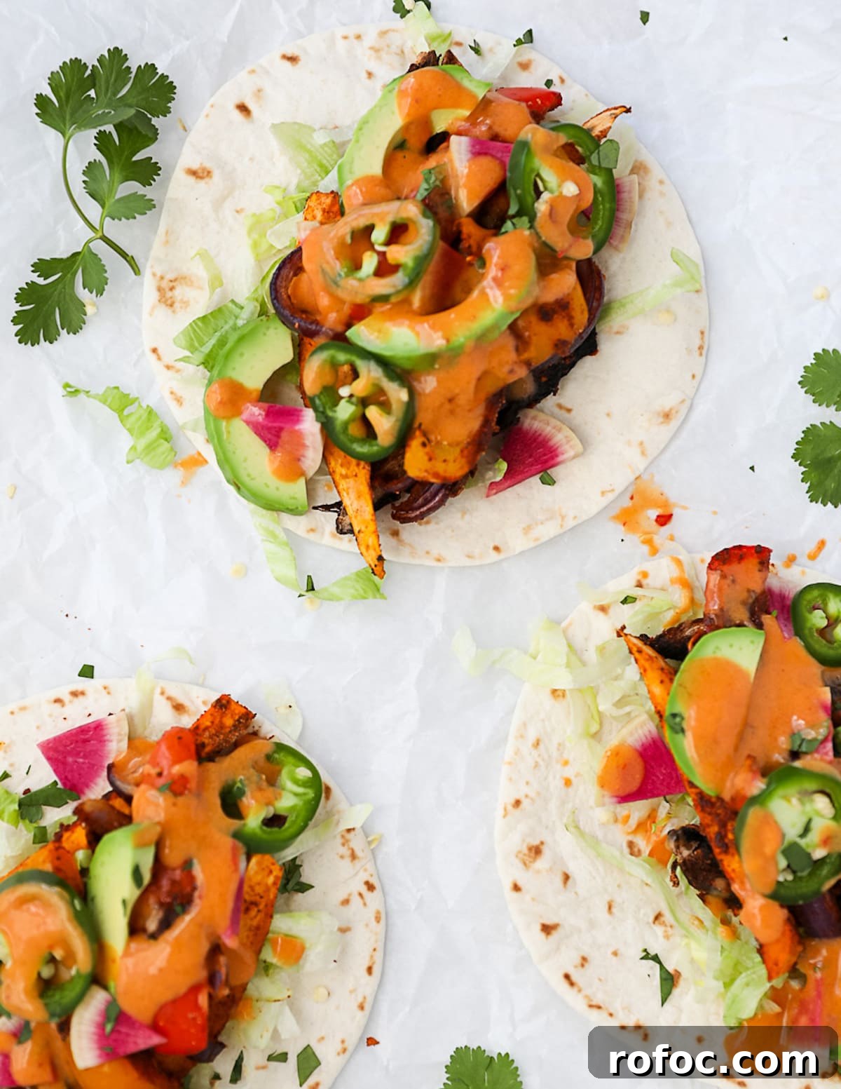 Flavor-Packed Veggie Tacos: Fresh Recipes for Every Night 6 Three tacos on white tortillas with roasted and fresh vegetables and a creamy chipotle sauce