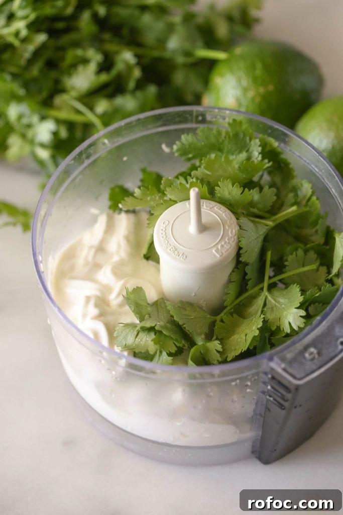 BBQ Chicken Taquitos with Cilantro-Lime Cream Sauce 3 A small food processor with the ingredients for the Cilantro Lime Cream in it.