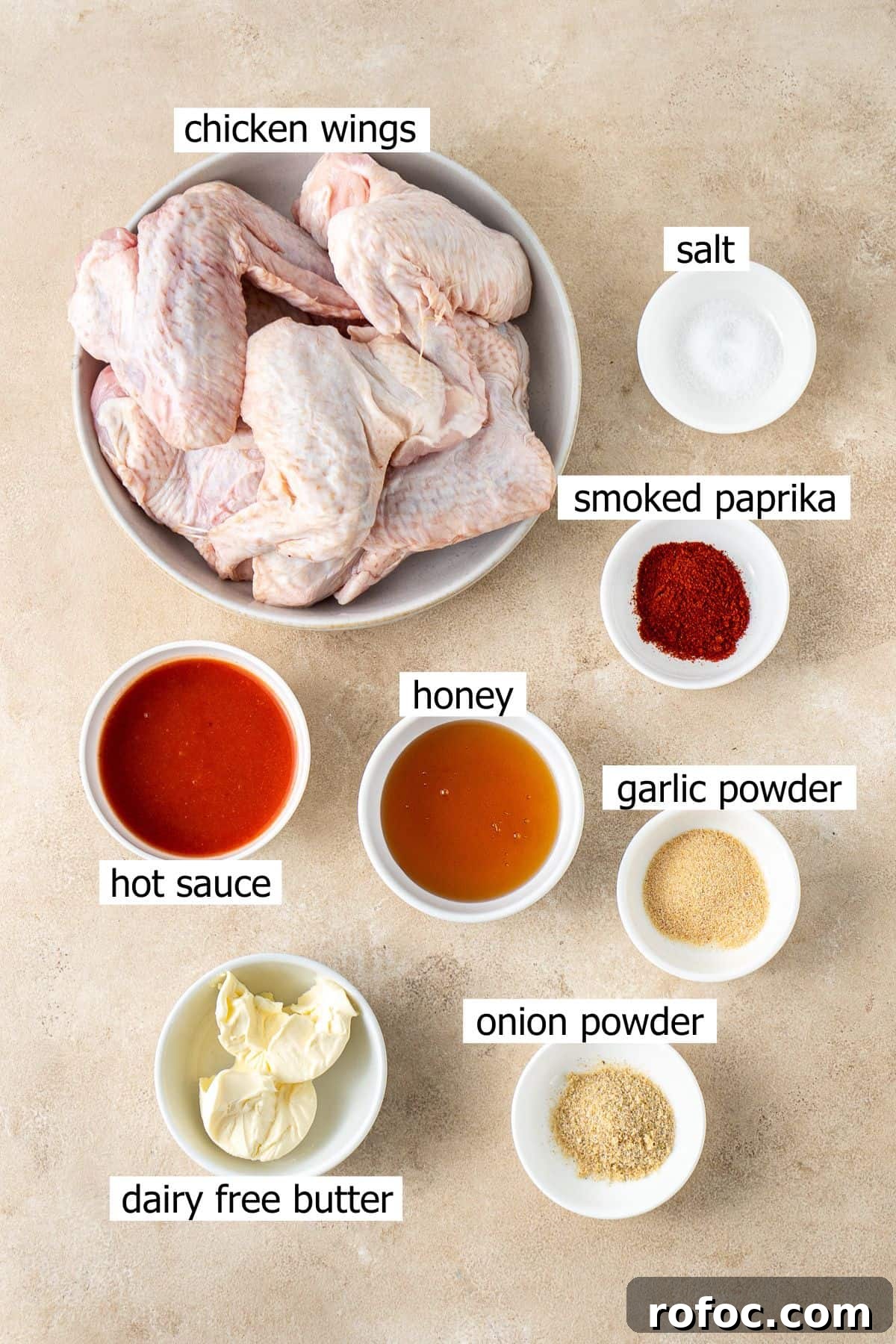 Spicy Honey-Glazed Chicken Wings Recipe for Game Day 3 All ingredients needed to make hot honey chicken wings laid out in small bowls.