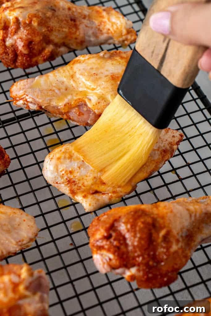 Spicy Honey-Glazed Chicken Wings Recipe for Game Day 7 Brushing the wings with melted butter before baking.