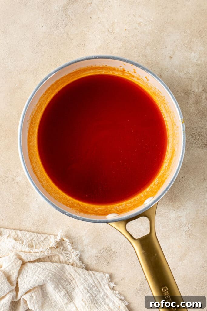Spicy Honey-Glazed Chicken Wings Recipe for Game Day 8 The hot honey sauce in a saucepan.
